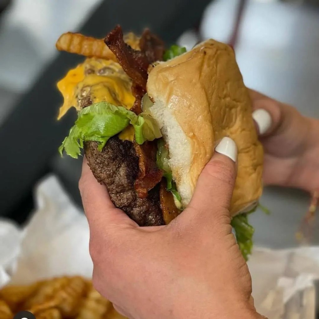 Juicy bacon cheeseburger with lettuce and crinkle fries